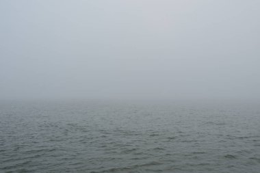 Sis içindeki Baltık Denizi. Dalgalar, su sıçratma, fırtına. Doğal dokular. Resimli panoramik monokrom manzarası, deniz manzarası. Doğa, çevre, sert hava, tehlike