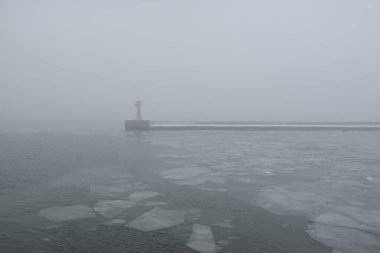 Sis içindeki Baltık Denizi. Dalgalar, su sıçratma, fırtına. Doğal dokular. Resimli panoramik monokrom manzarası, deniz manzarası. Doğa, çevre, sert hava, tehlike