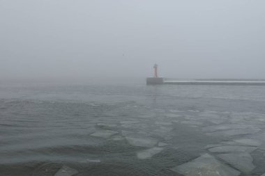 Sis içindeki Baltık Denizi. Dalgalar, su sıçratma, fırtına. Doğal dokular. Resimli panoramik monokrom manzarası, deniz manzarası. Doğa, çevre, sert hava, tehlike
