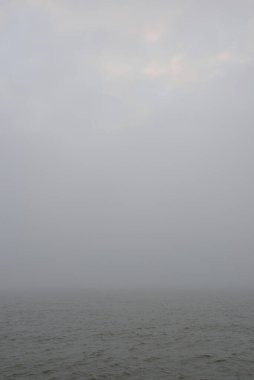 Sis içindeki Baltık Denizi. Dalgalar, su sıçratma, fırtına. Doğal dokular. Resimli panoramik monokrom manzarası, deniz manzarası. Doğa, çevre, sert hava, tehlike