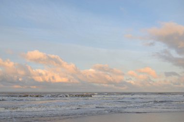 Kumlu bir sahilden (kum tepeleri) Baltık denizinin panoramik görüntüsü. Koyu bulutlu dramatik bir gökyüzü. Dalgalar, su sıçramaları. Idyllic deniz manzarası. Sıcak kış havası, iklim değişikliği, doğa. Danimarka