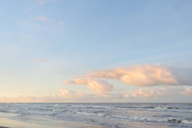 Kumlu bir sahilden (kum tepeleri) Baltık denizinin panoramik görüntüsü. Koyu bulutlu dramatik bir gökyüzü. Dalgalar, su sıçramaları. Idyllic deniz manzarası. Sıcak kış havası, iklim değişikliği, doğa. Danimarka