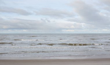 Kumlu bir sahilden (kum tepeleri) Baltık denizinin panoramik görüntüsü. Koyu bulutlu dramatik bir gökyüzü. Dalgalar, su sıçramaları. Idyllic deniz manzarası. Sıcak kış havası, iklim değişikliği, doğa. Danimarka