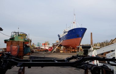 Karada duran eski gemi. Liman, tersane. Sanayi bölgesi. Ulaşım, onarım, servis. Havalandırma, Letonya, Baltık Denizi