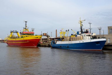Balıkçı teknesi (trol teknesi) kargo limanına demir attı. Baltık Denizi, Ventspils, Letonya. Ulaşım, geleneksel zanaat, lojistik, endüstri, özel ekipman