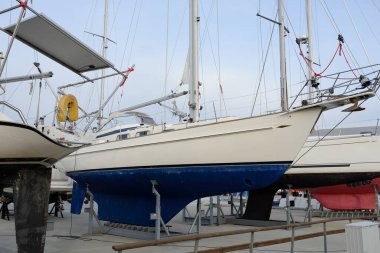 Sailboats standing on land in a yacht club. Service, repair, winterization, transportation, sport, recreation, leisure activity