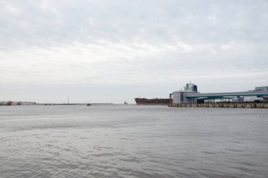 Kargo iskelesine demir atmış büyük bir gemi. Vinçler arka planda. Letonya 'da sızıntı var. Nakliye, endüstri, lojistik