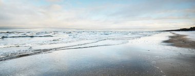 Gün batımında donmuş Baltık Denizi kıyısı, su yüzeyi dokusu. Resimli kış manzarası. Mevsimler, doğa, ekoloji, çevre, iklim değişikliği, küresel ısınma. Panorama, boşluğu kopyala