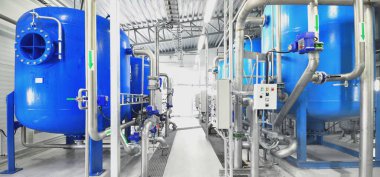 Large blue tanks in a industrial city water treatment boiler room. Wide angle perspective. Technology, chemistry, heating, work safety, supply, infrastructure