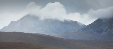 Dağlar, karanlık fırtına gökyüzünün altında zirve yapar. Dramatik bulutlar. Jura Adası, Inner Hebrides, İskoçya, İngiltere. Atmosferik manzara. Panoramik görünüm