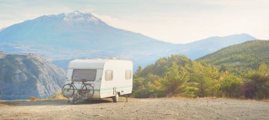 Lac de Serre-Poncon Gölü yakınlarındaki Fransız Alpleri manzaralı bir dağın tepesine park edilmiş karavan karavanı. Ulaşım, karavan, karavan, yol gezisi, kamp, turizm, eğlence, yaşam tarzı
