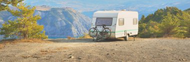 Lac de Serre-Poncon Gölü yakınlarındaki Fransız Alpleri manzaralı bir dağın tepesine park edilmiş karavan karavanı. Ulaşım, karavan, karavan, yol gezisi, kamp, turizm, eğlence, yaşam tarzı