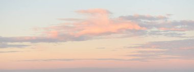 Gün batımında parlak pembe sirrus ve kümülüs bulutlarıyla açık mavi gökyüzü. Dramatik bulut manzarası. Sanat, meteoroloji, cennet, umut, barış, grafik kaynakları, resimli panoramik manzara