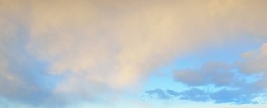 Açık mavi gökyüzü. Pembe ve altın rengi sirrus ve kümülüs bulutları fırtına üstüne, yumuşak güneş ışığı. Dramatik gün batımı bulutları. Meteoroloji, cennet, barış, grafik kaynakları, pitoresk panoramik manzara