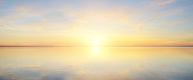 Yağmurdan sonra Baltık Denizi. Dramatik günbatımı gökyüzü, parlayan pembe ve altın bulutlar, suda simetri yansımaları. Soyut doğal desen, doku, arka plan. Resimli panoramik manzara