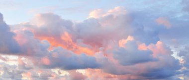 Açık mavi gökyüzü. Pembe ve altın rengi sirrus ve kümülüs bulutları fırtına üstüne, yumuşak güneş ışığı. Dramatik gün batımı bulutları. Meteoroloji, cennet, barış, grafik kaynakları, pitoresk panoramik manzara