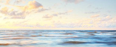 Gök gürültülü fırtınadan sonra denizin üstünde destansı, parlak, altın renkli günbatımı bulutları. Dramatik bir gökyüzü. Dalgalar ve su dokuya sıçrar. Idyllic deniz manzarası. Kavramsal görüntü, uzun pozlama. Resim gibi bir manzara.