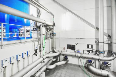 Endüstriyel şehir su arıtma kazan dairesinde büyük mavi tanklar. Geniş açılı bakış açısı. Teknoloji, kimya, ısıtma, iş güvenliği, arz, altyapı