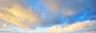 Açık mavi gökyüzü. Pembe ve altın rengi sirrus ve kümülüs bulutları fırtına üstüne, yumuşak güneş ışığı. Dramatik gün batımı bulutları. Meteoroloji, cennet, barış, grafik kaynakları, pitoresk panoramik manzara