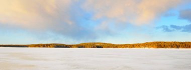 Gün batımında donmuş göl ve karla kaplı çam ormanı. Buz dokusu. Dramatik gökyüzü, yumuşak güneş ışığı. Idyllic kış sahnesi. Doğa, çevre koruma, ekoloji, iklim değişikliği, eko-turizm, Noel