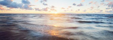 Gök gürültülü bir fırtınadan sonra denizin üstünde destansı pembe gün batımı bulutları. Dramatik bir gökyüzü. Dalgalar ve su dokuya sıçrar. Idyllic deniz manzarası. Kavramsal görüntü, uzun pozlama. Resim gibi bir manzara.