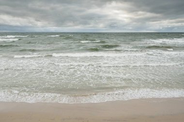 Fırtına sırasında Baltık Denizi. Dramatik gökyüzü, karanlık, parlak bulutlar. Dalgalar, su sıçramaları. Idyllic deniz manzarası. İklim değişikliği, doğa, kararsız hava, ekoloji