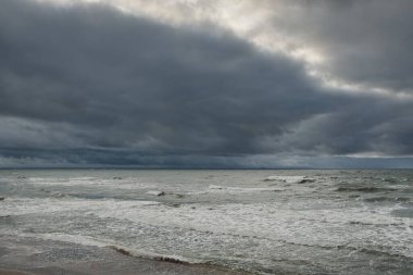 Fırtına sırasında Baltık Denizi. Dramatik gökyüzü, karanlık, parlak bulutlar. Dalgalar, su sıçramaları. Idyllic deniz manzarası. İklim değişikliği, doğa, kararsız hava, ekoloji