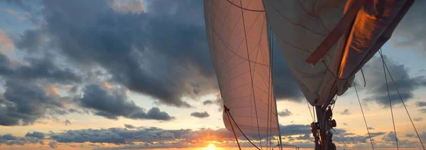 夕日の海でヨットセーリング デッキ マスト 帆の近くの景色 雨の後に澄んだ空 劇的な輝く雲 黄金の太陽の光 波と水のスプラッシュ サイクロン 叙事詩の海景 — ストック写真