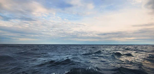 Baltık Denizi 'nin üzerindeki fırtınalı mavi gökyüzü. Dramatik parlayan bulutlar. Hanko Yarımadası, Finlandiya. Koyu deniz manzarası. Doğa, çevre, iklim değişikliği, hava durumu