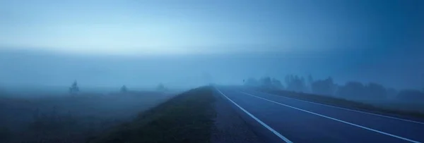 夜には霧の中でフィールドを介して空の高速道路のパノラマビュー 月明かり澄んだ空 日の出だ ヨーロッパだ 道路旅行 農村部 — ストック写真
