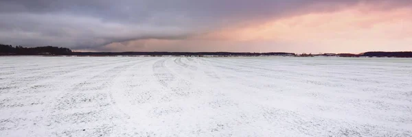 覆盖着白雪的耕地和拖拉机道 日落时分 云彩斑斓 冬季风景 拉脱维亚 温暖的冬天 气候变化 全球变暖 — 图库照片