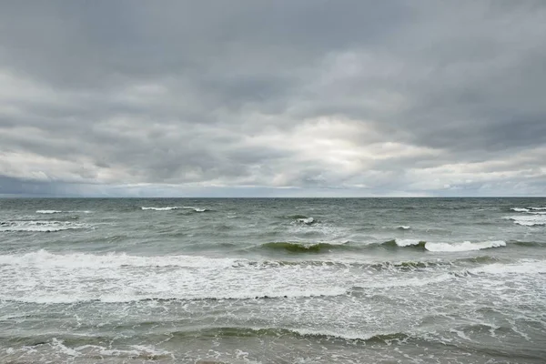 Fırtına sırasında Baltık Denizi. Dramatik gökyüzü, karanlık, parlak bulutlar. Dalgalar, su sıçramaları. Idyllic deniz manzarası. İklim değişikliği, doğa, kararsız hava, ekoloji