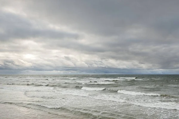 Fırtına sırasında Baltık Denizi. Dramatik gökyüzü, karanlık, parlak bulutlar. Dalgalar, su sıçramaları. Idyllic deniz manzarası. İklim değişikliği, doğa, kararsız hava, ekoloji