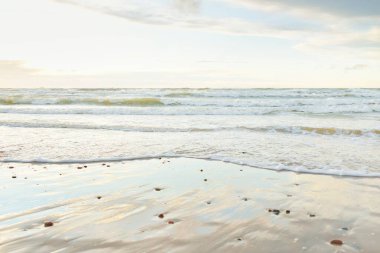Gün batımında Baltık kıyısı. Açık günbatımı gökyüzü, parlayan bulutlar. Idyllic manzara. Doğa, tatiller, eğlence. Çevre turizmi. Panoramik görünüm