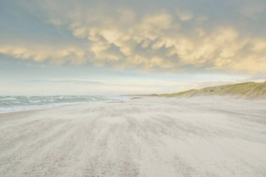Gün batımında Baltık kıyısı. Açık günbatımı gökyüzü, parlayan bulutlar. Idyllic manzara. Doğa, tatiller, eğlence. Çevre turizmi. Panoramik görünüm