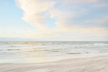 Gün batımında Baltık kıyısı. Açık günbatımı gökyüzü, parlayan bulutlar. Idyllic manzara. Doğa, tatiller, eğlence. Çevre turizmi. Panoramik görünüm