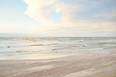Gün batımında Baltık kıyısı. Açık günbatımı gökyüzü, parlayan bulutlar. Idyllic manzara. Doğa, tatiller, eğlence. Çevre turizmi. Panoramik görünüm