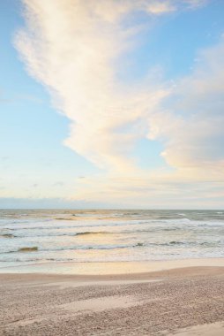 Gün batımında Baltık kıyısı. Açık günbatımı gökyüzü, parlayan bulutlar. Idyllic manzara. Doğa, tatiller, eğlence. Çevre turizmi. Panoramik görünüm
