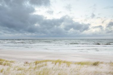 Gün batımında Baltık kıyısı. Açık günbatımı gökyüzü, parlayan bulutlar. Idyllic manzara. Doğa, tatiller, eğlence. Çevre turizmi. Panoramik görünüm