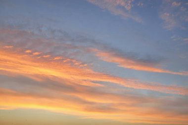 Açık mavi gökyüzü. Pembe ve altın renkli bulutlar. Gün doğumu. Dramatik bulut manzarası. Sanat, meteoroloji, cennet, umut, barış, grafik kaynakları, resimli panoramik manzara