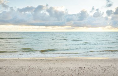 Gün batımında Baltık kıyılarından panoramik manzara. Dramatik bulutlar, parlayan bulutlar, fırtınadan sonra altın güneş ışığı. Doğa, çevre, iklim değişikliği, kararsız hava