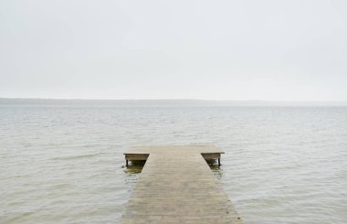 Yoğun bir siste orman nehri (göl). Ahşap iskele. Kasvetli gökyüzü, yağmur. Bulutlu bir gün. Idyllic manzara, kırsal manzara. Doğa, ekoloji, eko-turizm, yürüyüş, ekoloji beldesi, yerel turizm