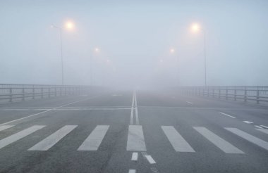 Yoğun bir siste, bomboş bir asfalt yolu (karayolu). Yaya geçidi, kavşak, sokak lambaları. Tehlikeli sürüş, yürüyüş, bisiklet, trafik kanunları