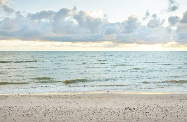 Gün batımında Baltık kıyılarından panoramik manzara. Dramatik bulutlar, parlayan bulutlar, fırtınadan sonra altın güneş ışığı. Doğa, çevre, iklim değişikliği, kararsız hava
