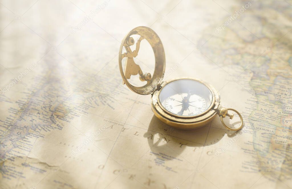 Retro style antique golden compass (sundial) and old nautical chart close-up. Vintage still life. Sailing accessories. Wanderlust, travel and navigation theme. Graphic resources, copy space