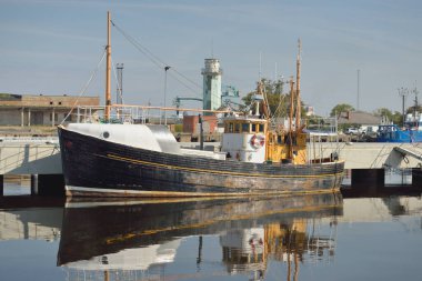 Eski bir ahşap klasik Kuzey Denizi balıkçı teknesi yat limanındaki bir rıhtıma demirlemiş. Denizcilik gemisi, ulaşım, geleneksel zanaat, sanayi