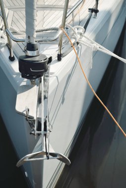 Beyaz modern yelkenli (kiralık ve satılık) yat limanındaki bir rıhtıma demirlemiş. Tahta meşe güvertesi. Denizcilik, ulaşım, amatör yelkencilik, tatiller, gezinti, eğlence kavramları