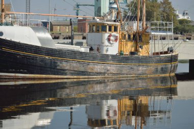 Eski bir ahşap klasik Kuzey Denizi balıkçı teknesi yat limanındaki bir rıhtıma demirlemiş. Denizcilik gemisi, ulaşım, geleneksel zanaat, sanayi
