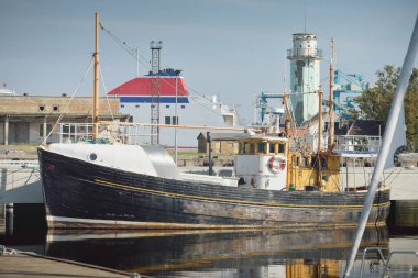 Eski bir ahşap klasik Kuzey Denizi balıkçı teknesi yat limanındaki bir rıhtıma demirlemiş. Denizcilik gemisi, ulaşım, geleneksel zanaat, sanayi