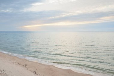 Panoramic aerial view from the Baltic sea shore at sunset. Dramatic cloudscape, glowing clouds, golden sunlight after the storm. Nature, environment, climate change, fickle weather